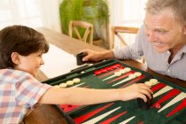 Grand-père et petit-fils jouant au backgammon — Photo de stock
