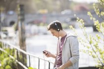Homem ouvindo fones de ouvido ao ar livre — Fotografia de Stock