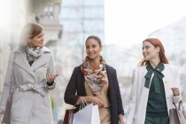Frauen mit Einkaufstüten reden und gehen in der Stadt — Stockfoto
