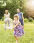 Glückliche Familie spielt mit Blasen im Hinterhof — Stockfoto