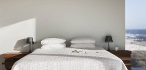Sonne auf weißem Bett mit Meerblick — Stockfoto