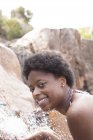Portrait of smiling woman at waterfall — Stock Photo