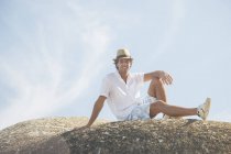Mann sitzt auf Felsformation — Stockfoto