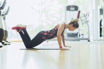 Frau macht Liegestütze auf Knien im Fitnessstudio — Stockfoto