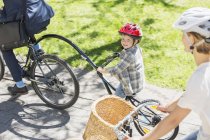 Retrato sorridente menino equitação tandem bicicleta com pai no parque — Fotografia de Stock