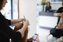 Hairdresser rolling customers hair in rollers in salon — Stock Photo