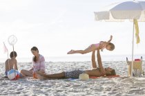 Familia relajándose juntos en la playa - foto de stock