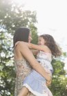 Affectionate mother holding and hugging daughter outdoors — Stock Photo