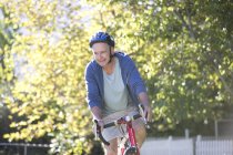 Senior man riding bicycle in park — Stock Photo