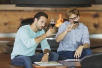 Men wine tasting red wine in winery tasting room — Stock Photo