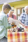Boy drawing honey sign for farmers market stall — Stock Photo