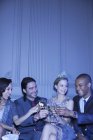 Amigos bien vestidos brindando flautas de champán - foto de stock
