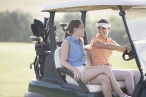 Frauen fahren Karren auf Golfplatz — Stockfoto