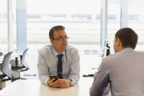 Businessmen talking together in modern office — Stock Photo