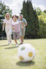 Happy grandparents and grandson playing soccer — Stock Photo