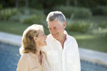 Senior couple at poolside — Stock Photo