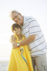 Nonno che abbraccia nipote sulla spiaggia — Foto stock