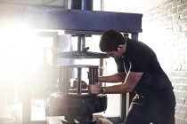 Mechaniker mit Reifenmontiermaschine in Autowerkstatt — Stockfoto