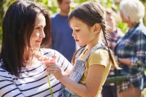Mother holding daughter with flower — Stock Photo