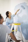 Couple painting wall blue — Stock Photo