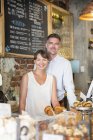 Ritratto sorridente caffè proprietario coppia dietro il bancone — Foto stock