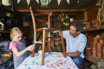 Padre e figlia che dipingono sedia in laboratorio — Foto stock