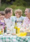 Family enjoying lunch at table outdoors — Stock Photo