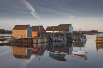 Гребные лодки и здания на спокойном заливе — стоковое фото