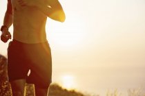 Mann mit nacktem Oberkörper läuft bei Sonnenuntergang — Stockfoto