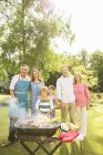 Семья из нескольких поколений стоит на барбекю на заднем дворе — стоковое фото