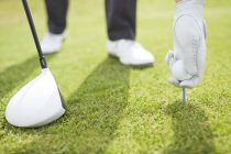 Vista ritagliata di uomo teeing pallina da golf in corso — Foto stock