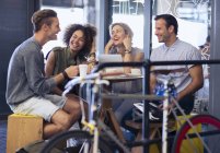 Friends hanging out in cafe behind bicycle — Stock Photo