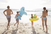 Family playing together on beach — Stock Photo