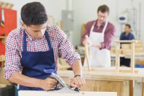 Junge Tischlerin setzt in Werkstatt Hobelwerkzeug ein — Stockfoto