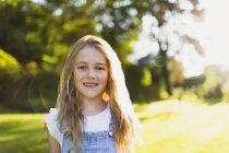 Porträt lächelndes Mädchen im sonnigen Garten — Stockfoto