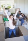 Mädchen spielt in Pappkiste in neuem Haus — Stockfoto