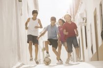 Діти грають з футбольним м'ячем у алеї — стокове фото