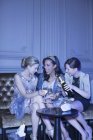 Des femmes bien habillées buvant du champagne dans une boîte de nuit de luxe — Photo de stock