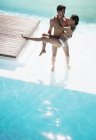 Jovem casal atraente relaxante na piscina — Fotografia de Stock