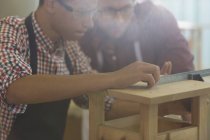 Schreinermeister messen Holz mit Lineal in Werkstatt — Stockfoto