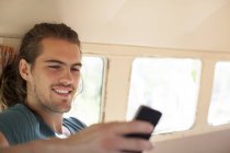 Mann benutzt Handy in Wohnmobil — Stockfoto