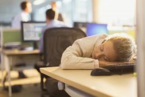 Бізнес-леді спить на столі в офісі — стокове фото