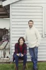 Портрет усміхненої пари в светрах п'є каву за межами будинку — стокове фото