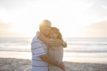 Casal sênior abraçando na praia — Fotografia de Stock