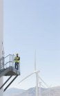 Arbeiter steht auf Windkraftanlage in ländlicher Landschaft — Stockfoto