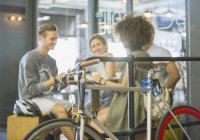 Friends hanging out at cafe behind bicycle — Stock Photo
