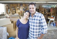 Retrato de casal sorridente fora garagem entre caixas de papelão — Fotografia de Stock