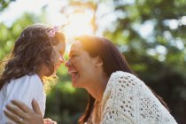 Энтузиастичные мать и дочь улыбаются лицом к лицу — стоковое фото