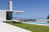 Gramado e piscina ao longo da casa moderna — Fotografia de Stock