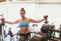 Femme concentrée faisant haltère poitrine voler à la salle de gym — Photo de stock